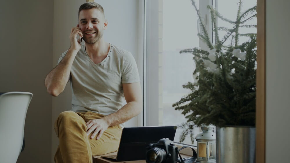 A man on a mobile phone with a laptop computer
