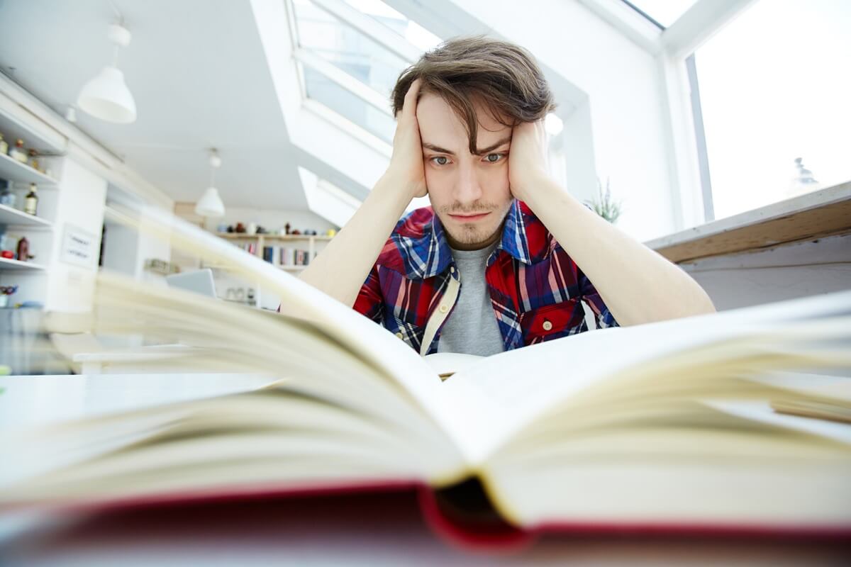 A college learner studying with a book