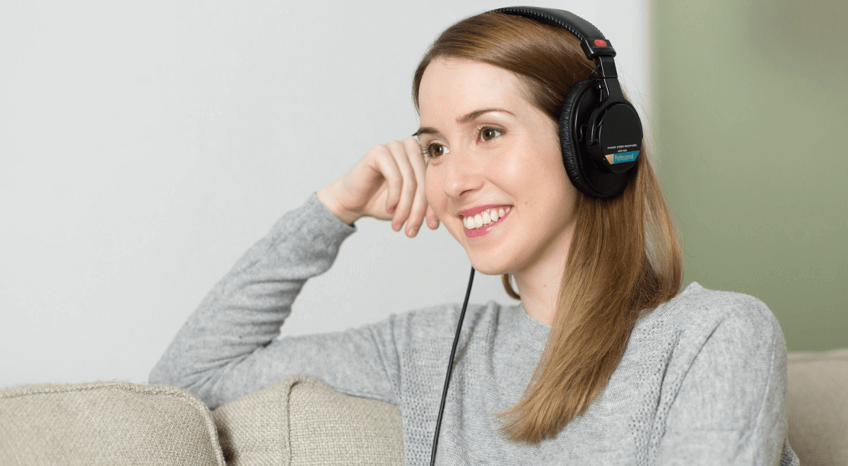 A woman learning a language by listening to it on headphones