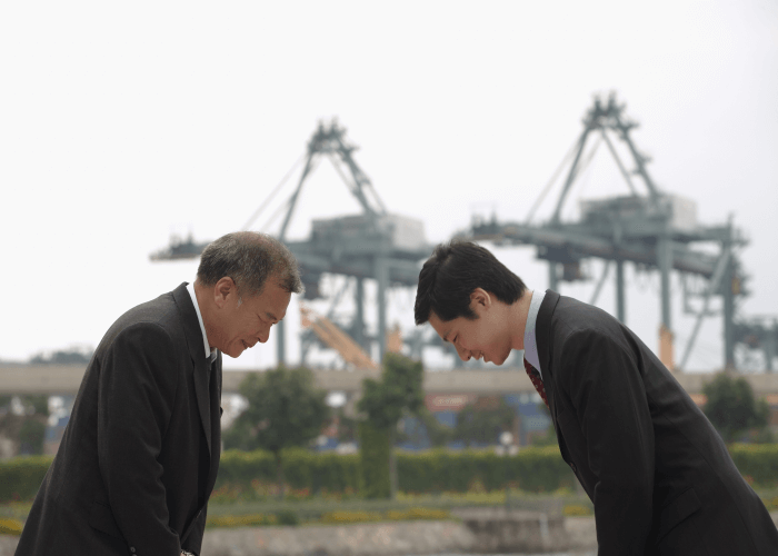 Two Japanese businessmen bowing in greeting each other