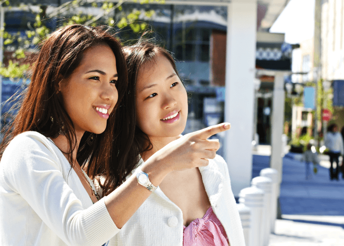 Two young Japanese women pointing and describing something